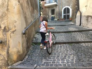 Little Italian girl with her pink bike in Ronciglione