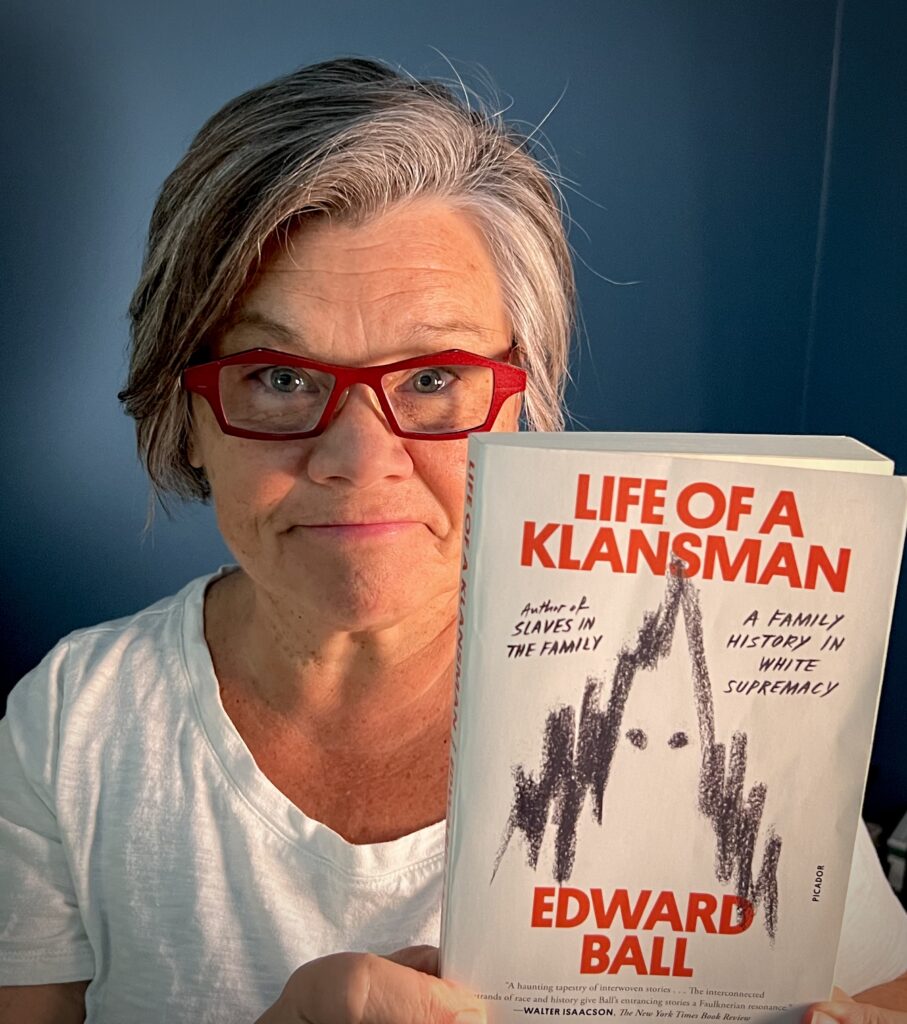 Tamela holding a copy of Edward Ball's book, "Life of a Klansman: A History of White Supremacy." She considers this the most impactful book she read in 2023.