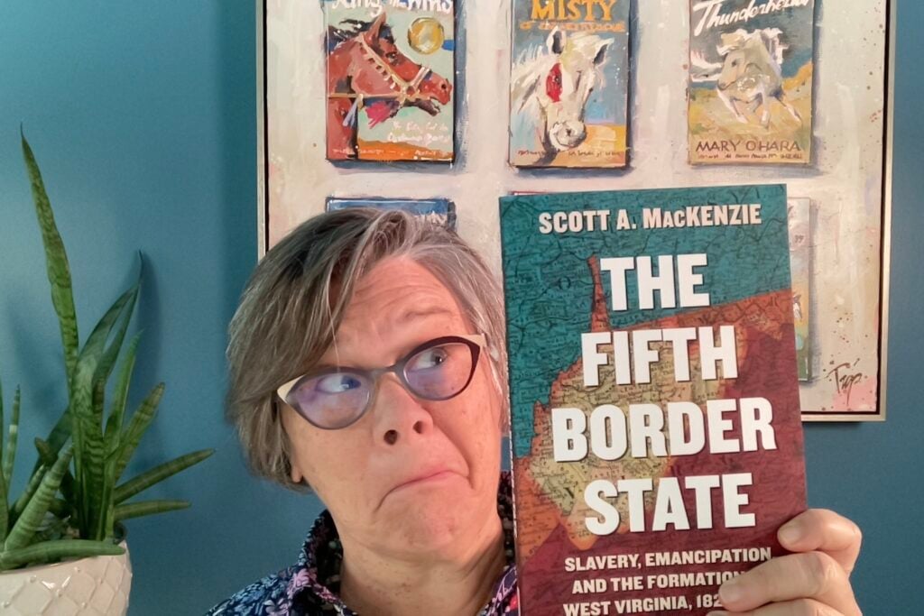 Tamela holding Scott A. MacKenzie's book, "The Fifth Border State" about why and how West Virginia stayed in the Union instead of seceding with the rest of Virginia